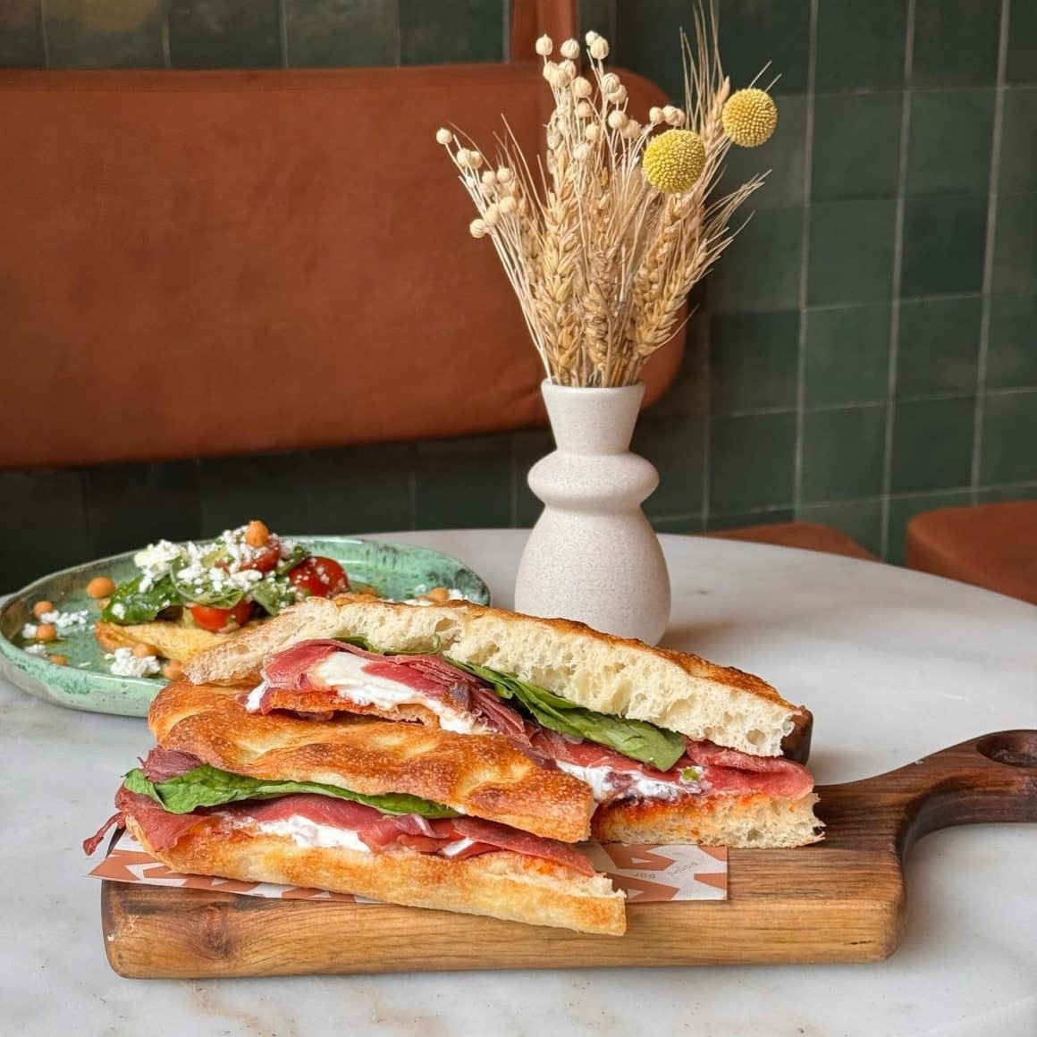 Sandwich tip panini cu Nduja, Prosciutto, burrata, caramelized onions, and baby spinach