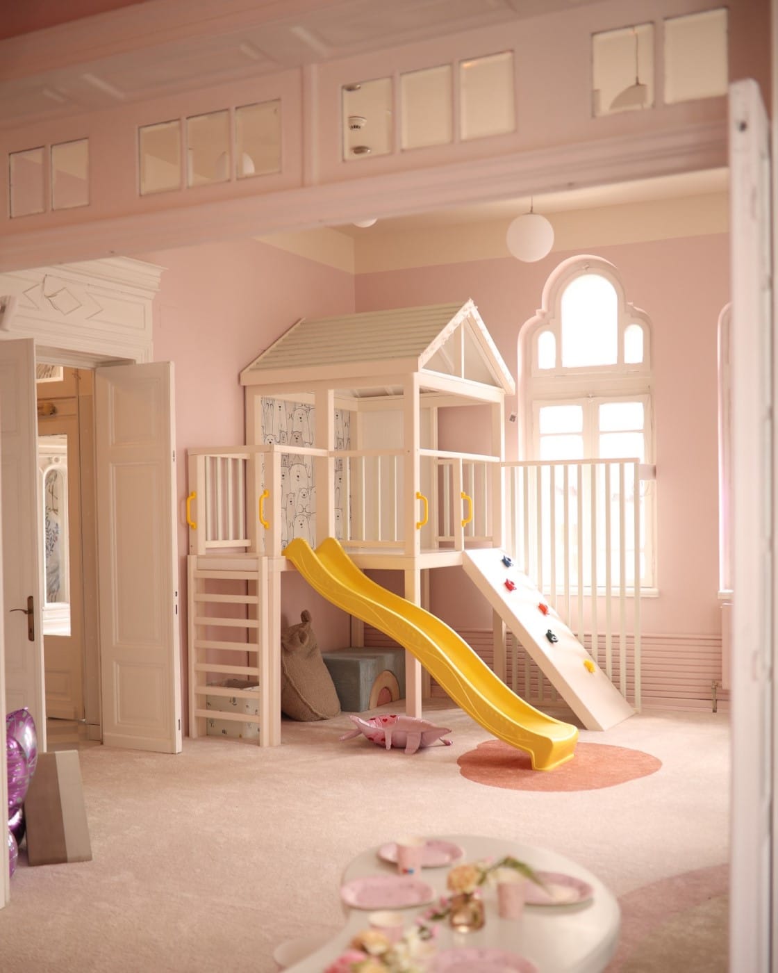 imagine cu o incapere roz si un ansamblu de joacă cu tobogan de la de la CUIB de joacă