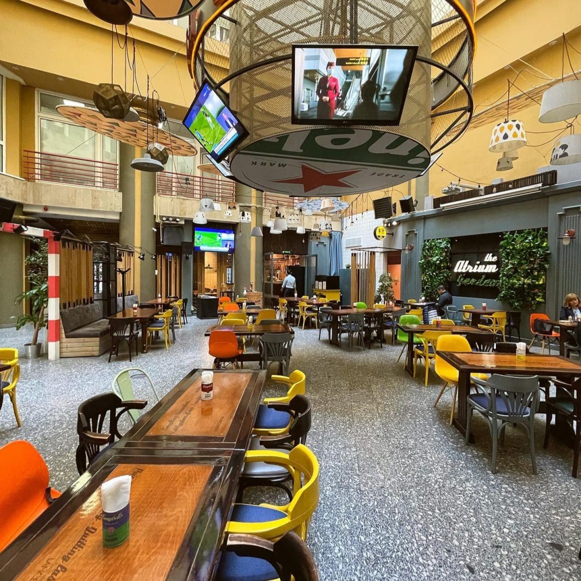 sala de mese de la restaurant Stadio, cu atrium, unde sunt suspendate ecrane TV