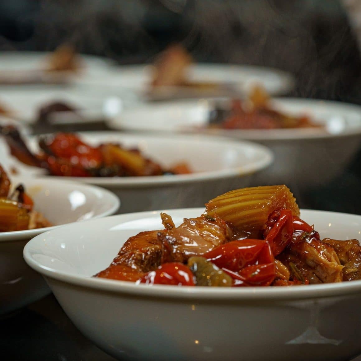 close up cu o farfurie cu paste aburinde, cu sos rosu si rosii