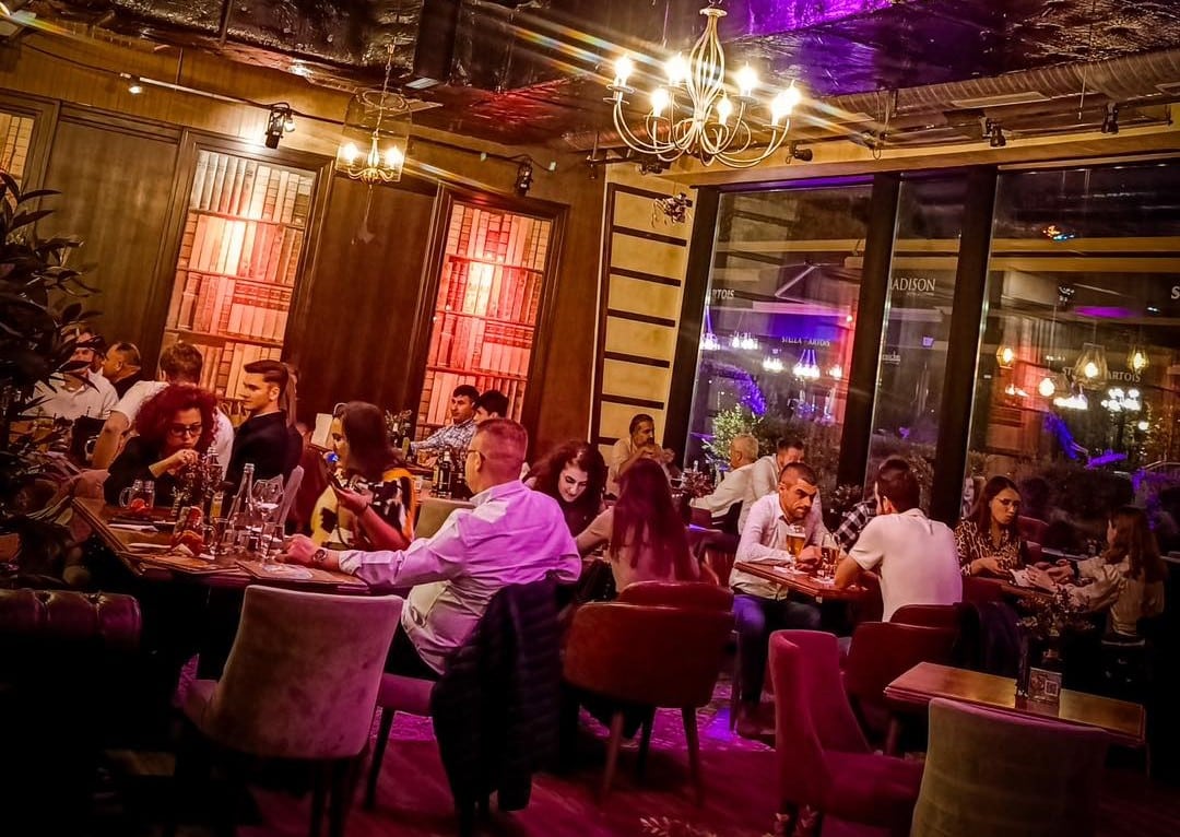 mai multi oameni iau masa in interior la restauran Madison din Iași