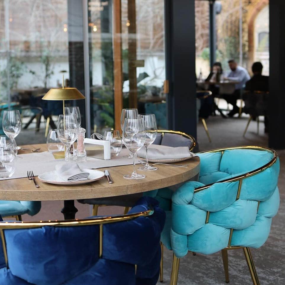 prim plan cu o masa eleganta cu scaune din catifea albastru inchis si belo, la roa primăverii