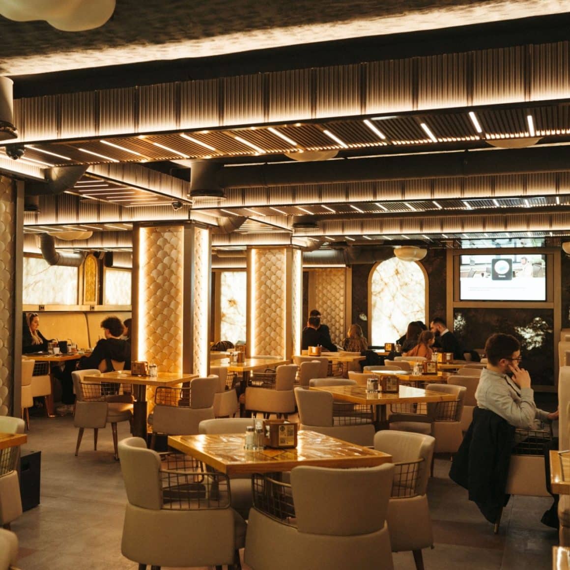 interiorul elegant de la restaurant Mamma Mia din Iași, decorat cu mult auriu și lumini ambientale