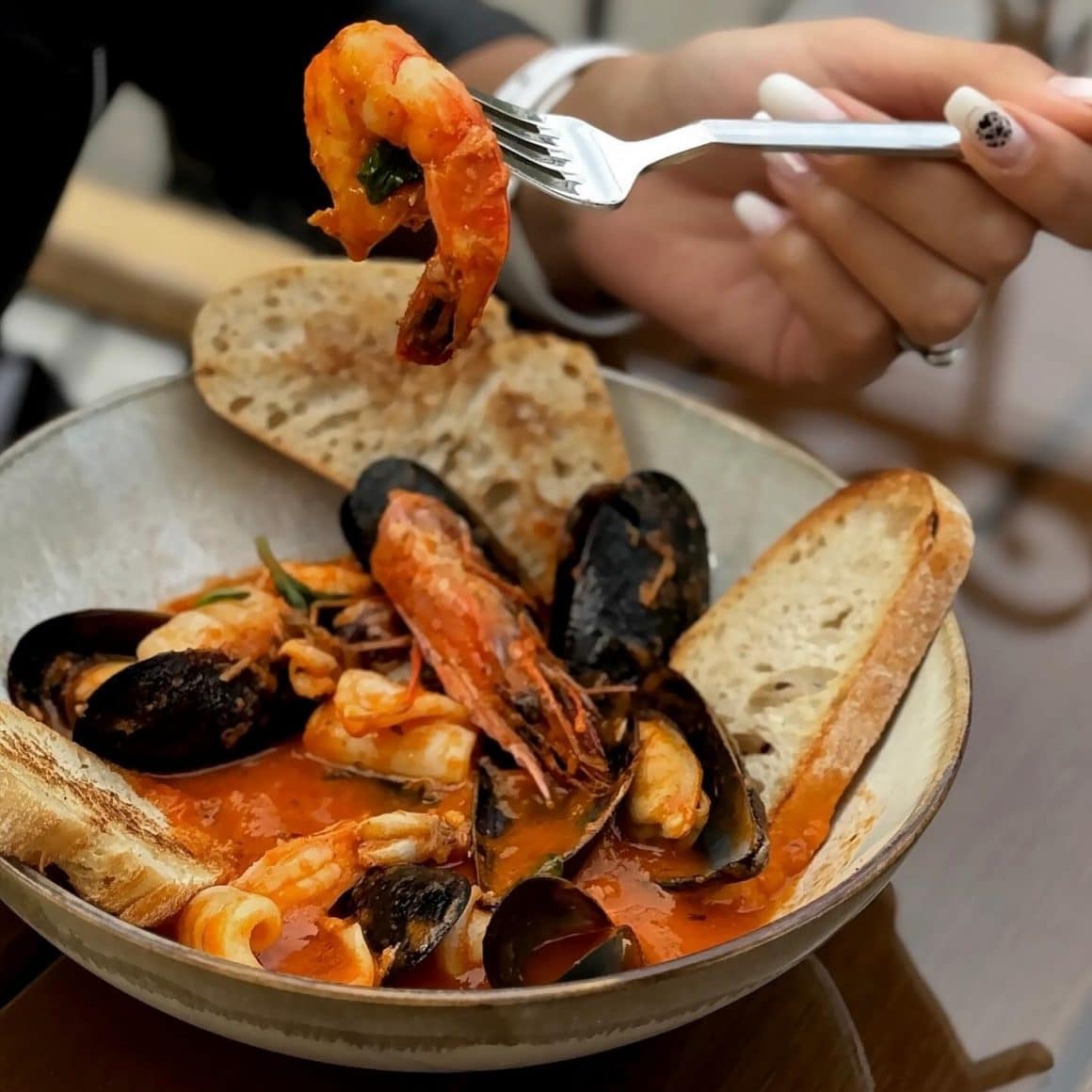 close up cu o farfurie cu fructe de mare servite in sos roșu