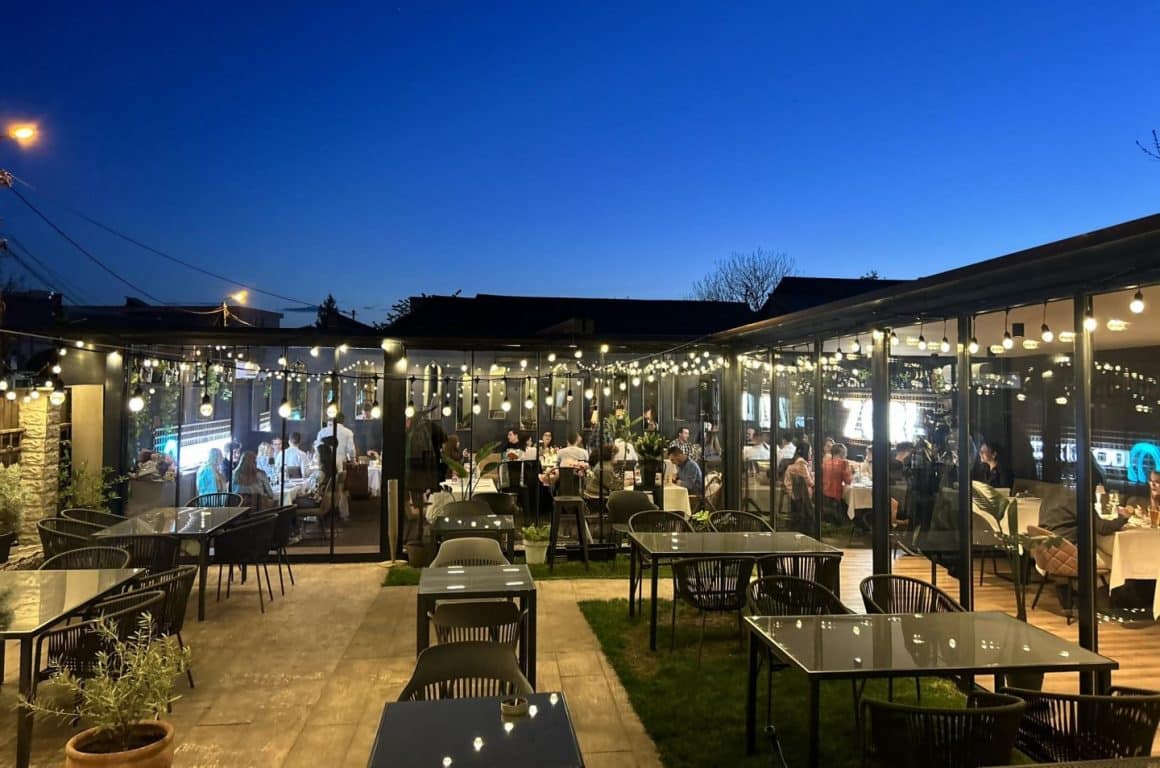 Restaurantul Zori din Iași, fotografiat de pe terasa cu privire la interior, plin de oameni care iau masa