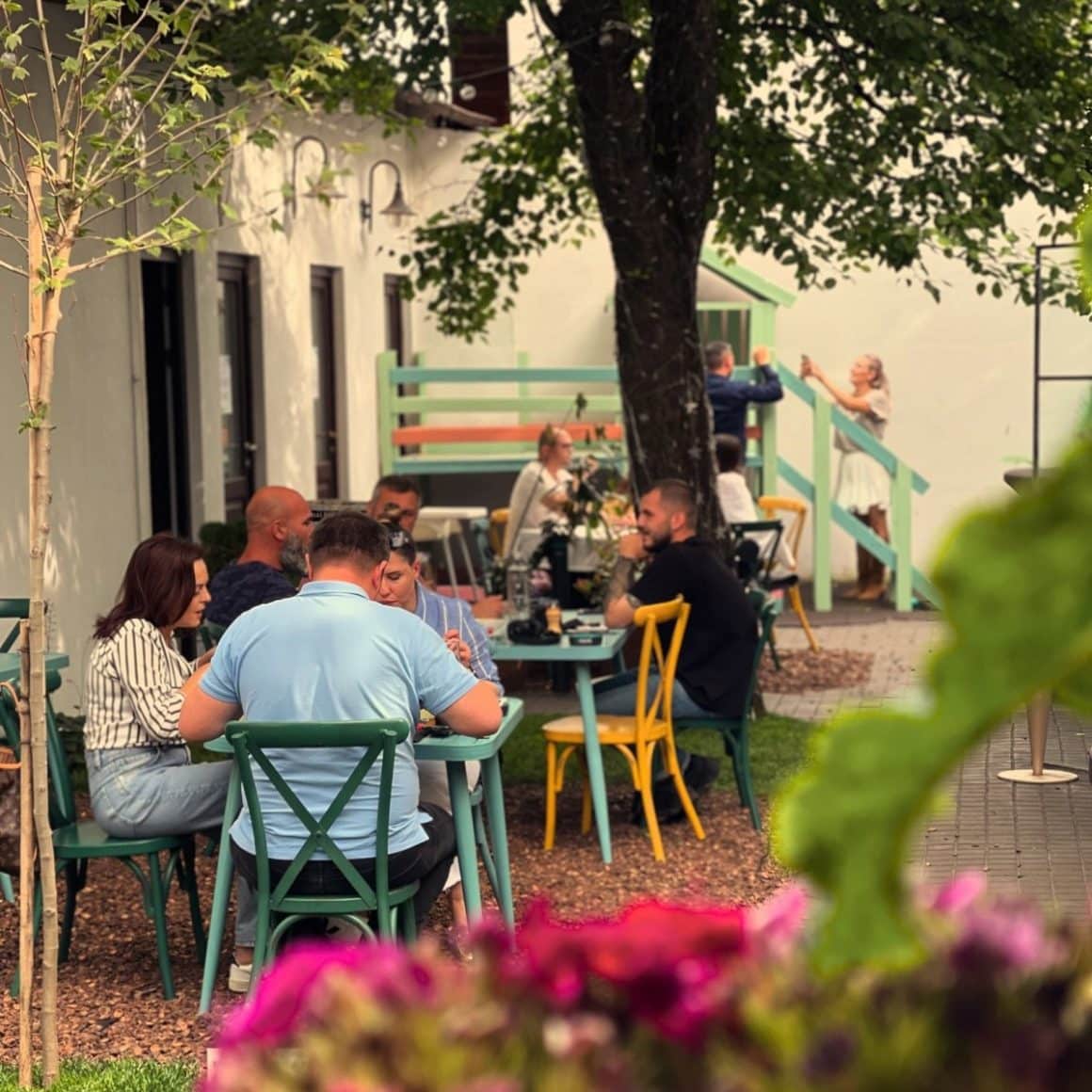 mai multi oameni iau pranzul pe terasa la Krud. restaurante Iași