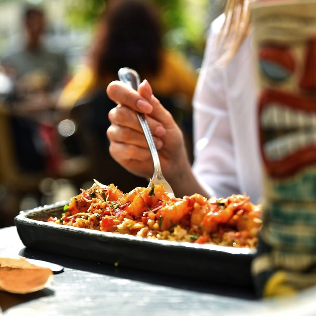 close up cu o farfurie din care mananca o femeie. Butterfly Shrimps.