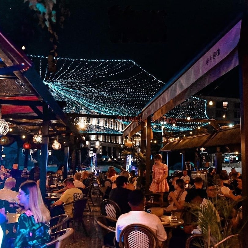 mai mulți oameni adunați pe terasa, seara, la Tiki Bistro. restaurante din Iași