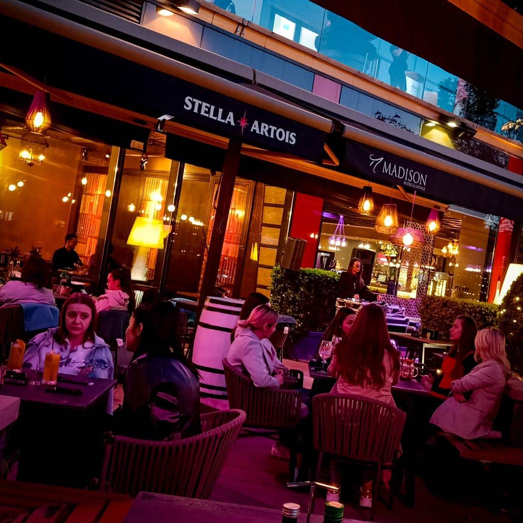 mai multi oameni iau masa pe terasa la restaurant Madison din Iași. restaurante Iași