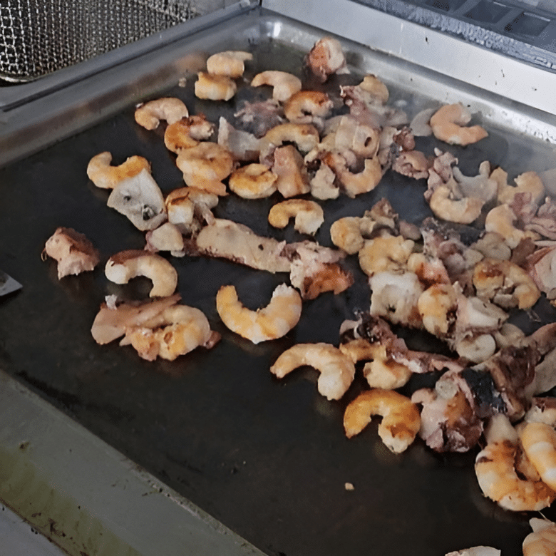 Fructe de mare (caracatita, calamar, creveti) facuti grill pe o plita incinsa la Georges Fischery. Restaurante cu fructe de mare București.