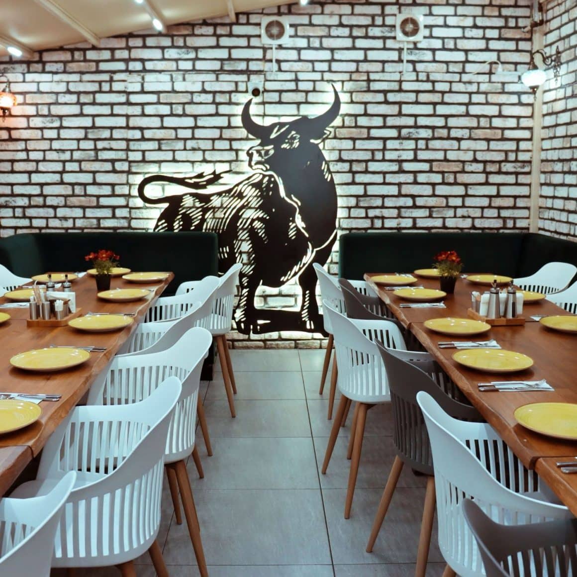 interiorul de la AYT Steakhouse, cu un perete cu tapet din caramida si un taur pictat. Cele mai bune restaurante turcești din București