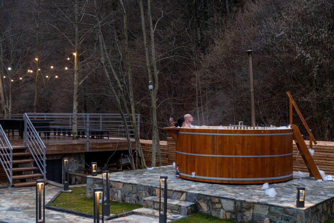 un cuplu se relaxeaza in ciubar, in curtea unei cabana la munte. cabana iuli's home