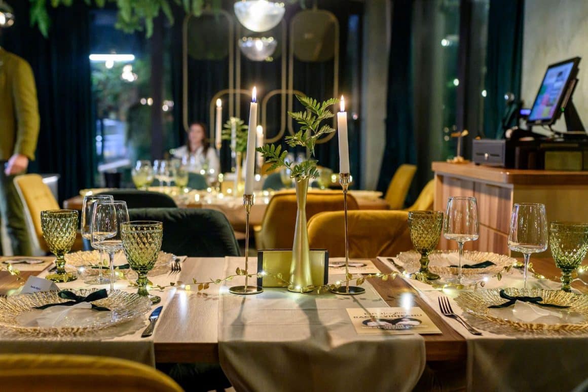 masa de revelion decorata festiv, cu lumanari si vesela eleganta