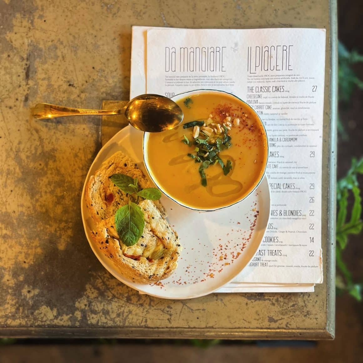 bol cu supa crema de morcov sau dovleac, servit pe o farfurie cu paine prajita, la Frog București