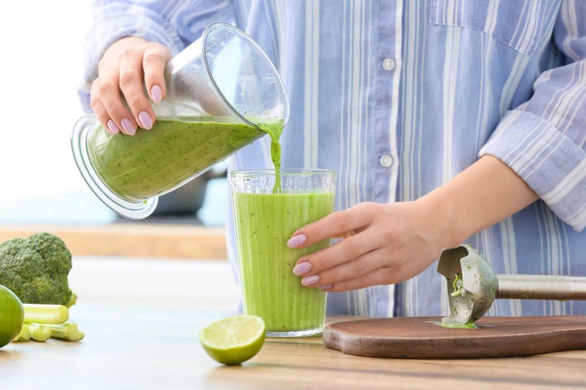 cineva isi toarna in pahar un smoothie verde. Sucuri detox