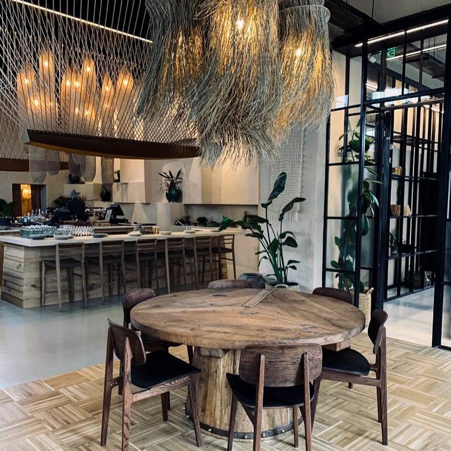 Masa rotunda si un copr de iluminat decorativ, special, la Pot Stories. Restaurante pentru o ieșire cu fetele