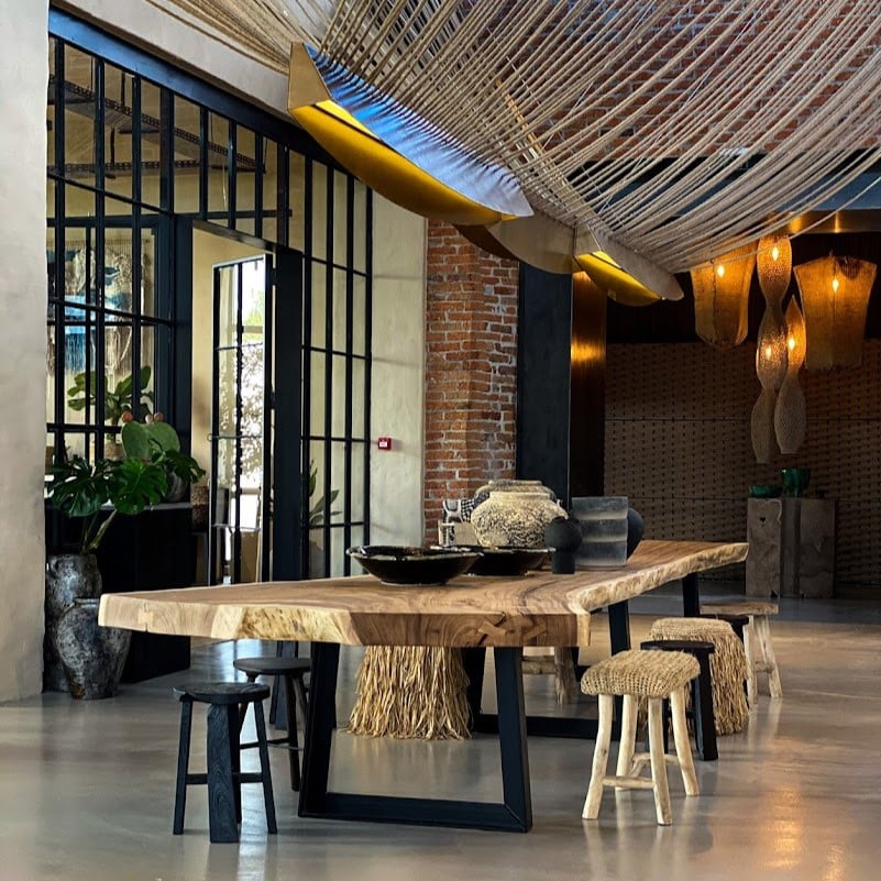 Masa lunga, din lemn, asezata sub un obiect decorativ de fire testute, la Pot. Stories București