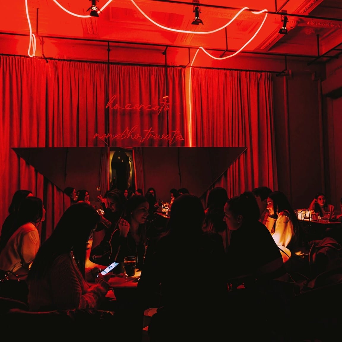 Un grup de fete ia masa la La Grande Bellezza din București, într-un decor cu draperii mari din catifea si lumina roșie. Restaurante pentru o ieșire cu fetele