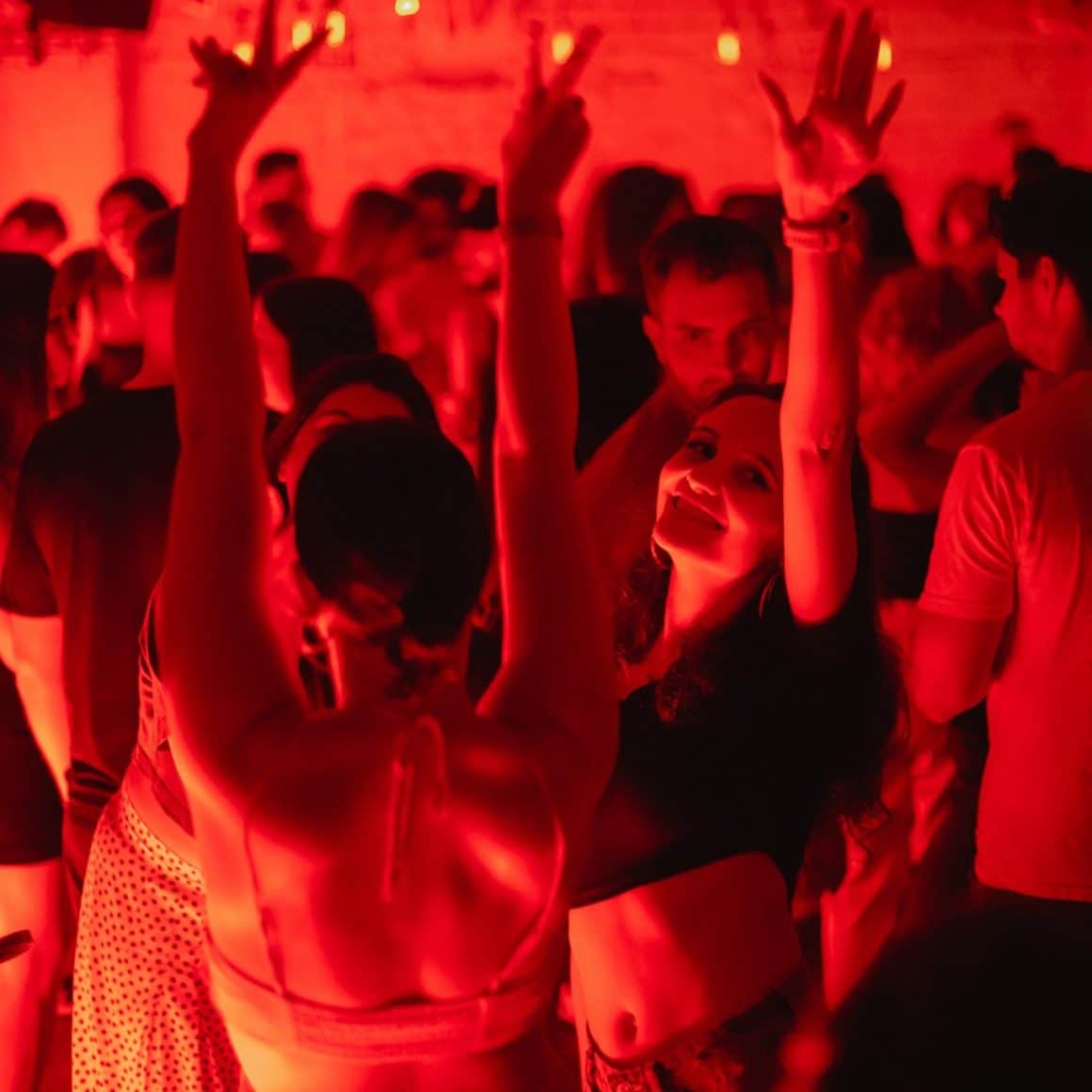 Mai multe fete danseaza la Interbelic Cocktail Bar. In lumina rosie. Restaurante pentru o ieșire cu fetele